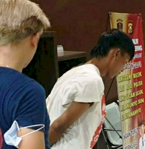 Sandi digiring anggota Polrestabes Palembang atas laporan melakukan aksi penodongan di Jembatan Ampera. (Ist)