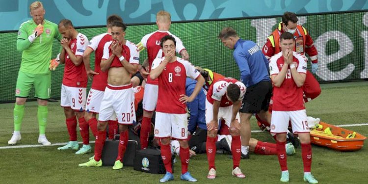 Pemain Denmark berdiri mengelilingi Eriksen yang tengah mendapat perawatan. (Net/rmolsumsel.id)