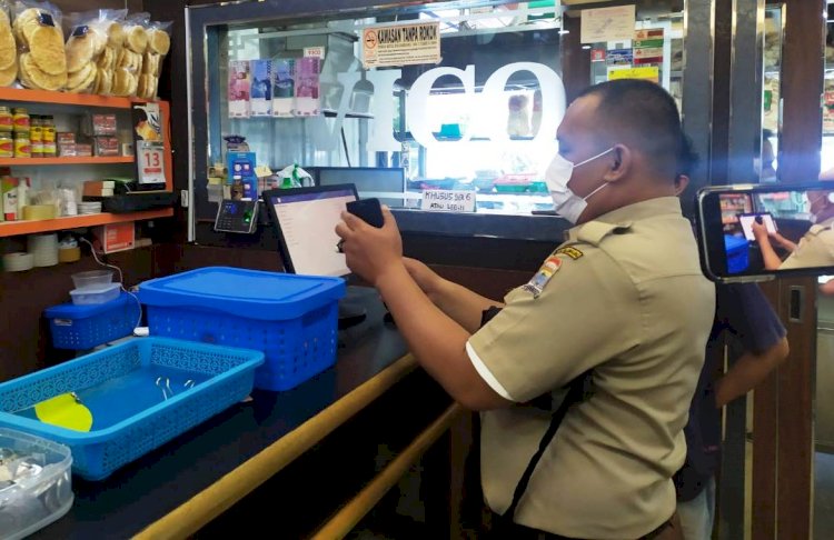 Petugas BPPD Kota Palembang memeriksa e-Tax yang terpasang di mesin kasir restoran Pempek Vico. (bakohumas palembang/rmolsumsel.id)