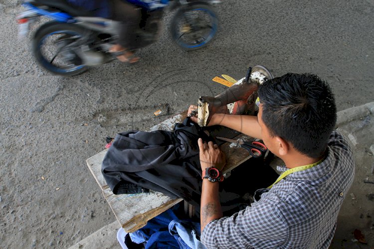 Penjahit jalanan yang berada di bawah Jembatan Ampera Palembang. (M Hatta/rmolsumsel.id)