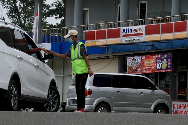 Seorang jukir menerima uang parkir di kawasan Ilir Barat I Palembang, Sumsel, Rabu (16/6). (M Hatta/rmolsumsel.id)