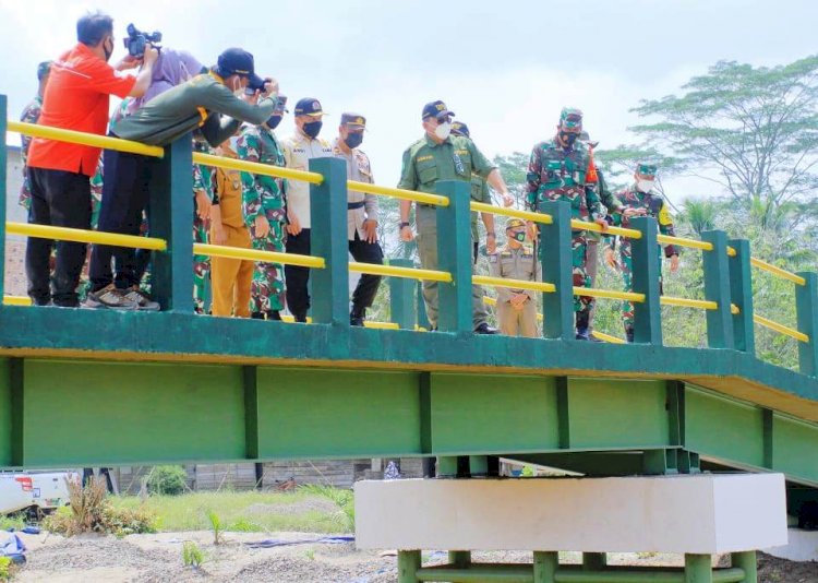 Bupati Muba Dodi Reza Alex bersama pejabat TNI AD berdiri di atas jembatan komposit yang dibangun melalui program TMMD ke-111. (Humas Pemkab Muba/rmolsumsel.id)