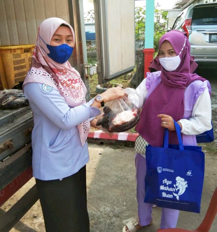 Pegawai Dinas Perikanan Kabupaten Muba membagikan ikan ke warga. (Humas Pemkab Muba/rmolsumsel.id)