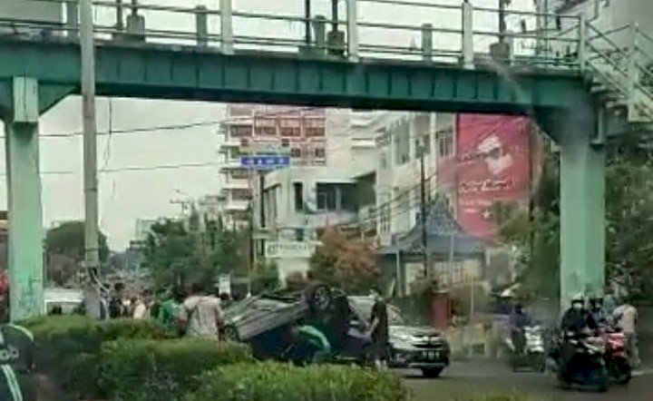 Sebuah Mobil Daihatsu Sigra hitam terguling saat melintas di Jalan Jenderal Sudirman, Km 3,5 Palembang, Selasa (13/7) siang. (ist/rmolsumsel.id)