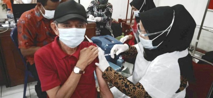 Vaksinator menyuntikkan vaksin ke seorang warga pada vaksinasi massal di kantor DPC PDI Perjuangan Kota Palembang. (Ist/rmolsumsel.id)