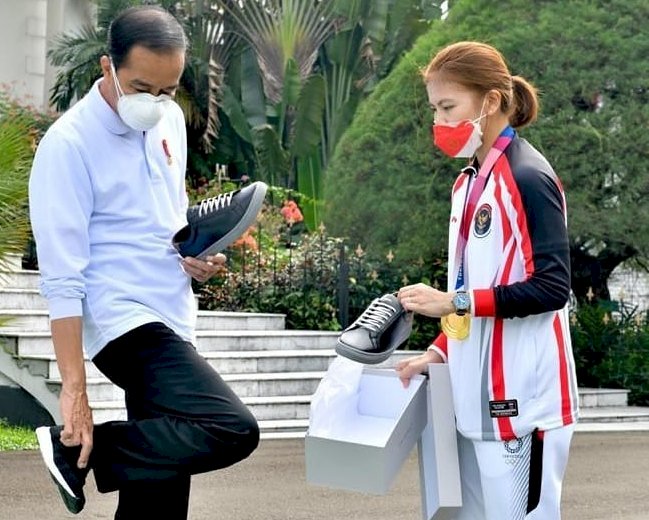 Presiden Joko Widodo saat akan mencoba sepatu produksi Greysia Polii