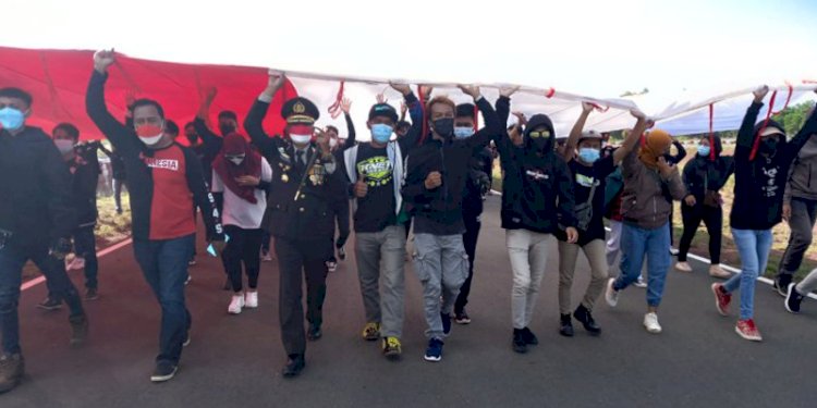 Kapolres Merauke AKBP Ir. Untung Sangaji, M. Hum memimpin pembentangan bendera merah putih raksasa di Merauke dalam peringatan HUT RI ke-76. (rmolpapua.id)