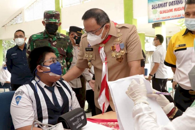 Bupati Muba Dodi Reza Alex berbincang dengan salah satu siswa SMP Negeri 6 Unggul Sekayu yang akan menjalani vaksinasi Covid-19. (Humas Pemkab Muba/rmolsumsel.id)