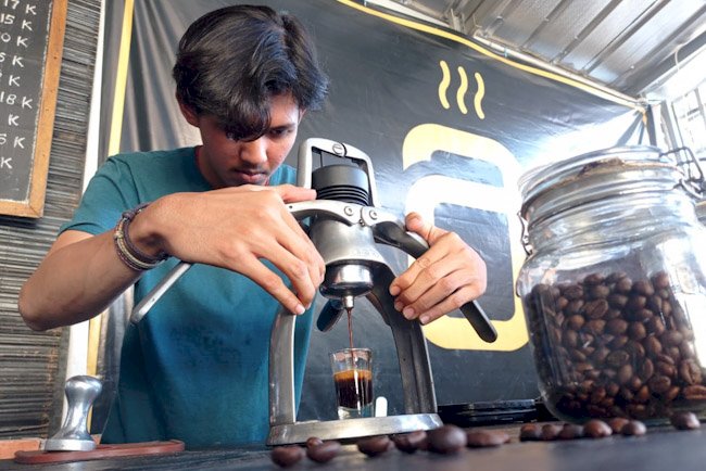 Salah seorang barista di Kota Palembang tengah menyajikan kopi. (eko prasetyo/rmolsumsel.id)