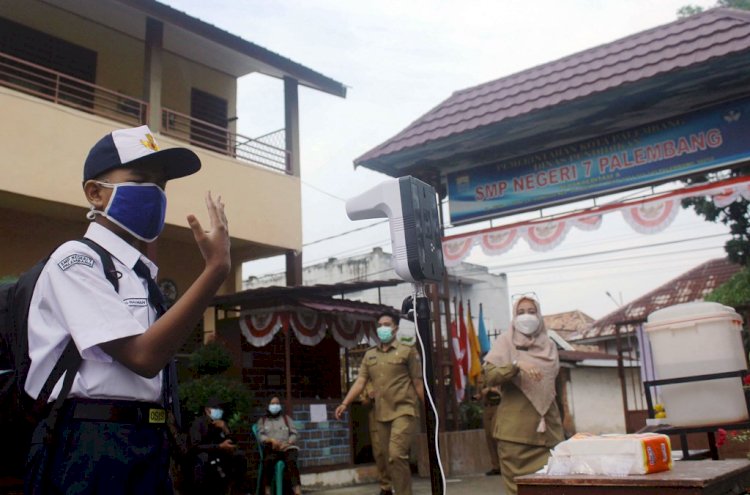 Seorang siswa SMP Negeri 7 Palembang mengecek suhu sebelum masuk ke kelas. (Humaidy Kenedy/rmolsumsel.id)