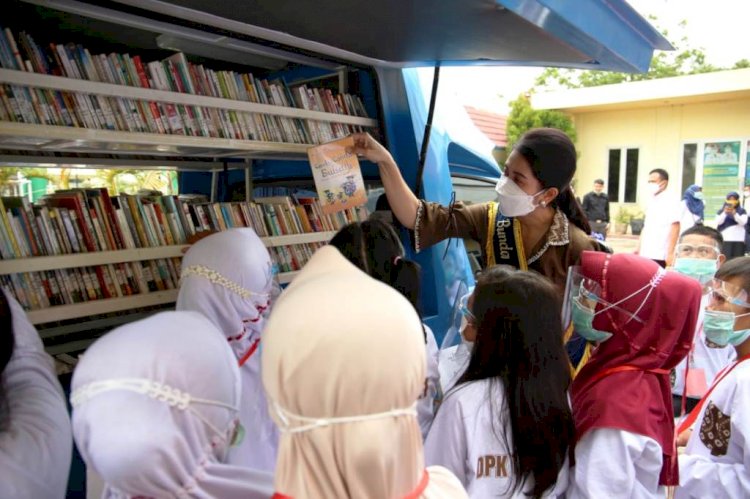 Bunda Baca Muba Thia Yufada mengajak anak-anak untuk membaca koleksi yang ada di Perpustakaan Keliling. (Humas Pemkab Muba/rmolsumsel.id) 