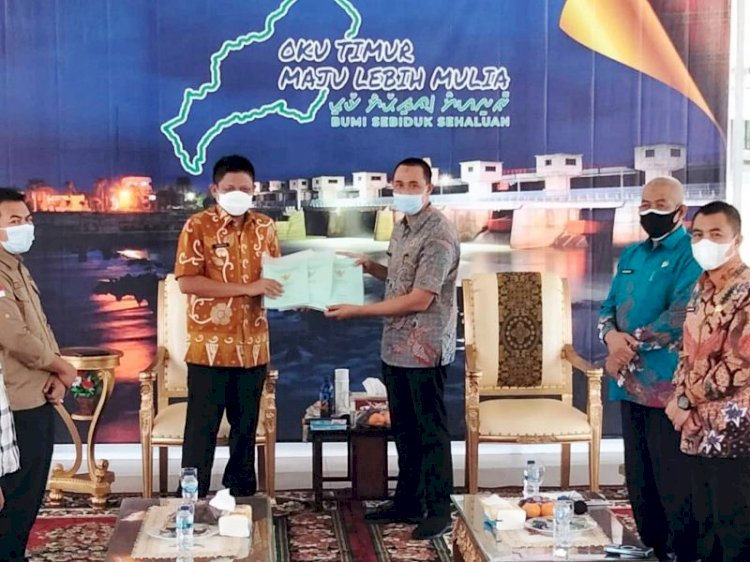 Bupati OKU Timur Lanosin Hamzah menerima sertifikat tanah aset Pemda yang diserahkan Kepala BPN OKU Timur Mahyuddin. (Dinas Kominfo OKU Timur/rmolsumsel.id)