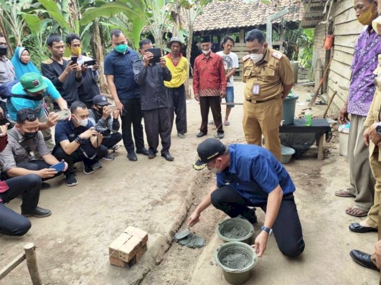 Bupati OKU Timur Lanosin meletakkan batu pertama memulai bedah rumah warga di Desa Tunas Peracak, Selasa (28/9). (Dinas Kominfo OKU Timur/rmolsumsel.id)