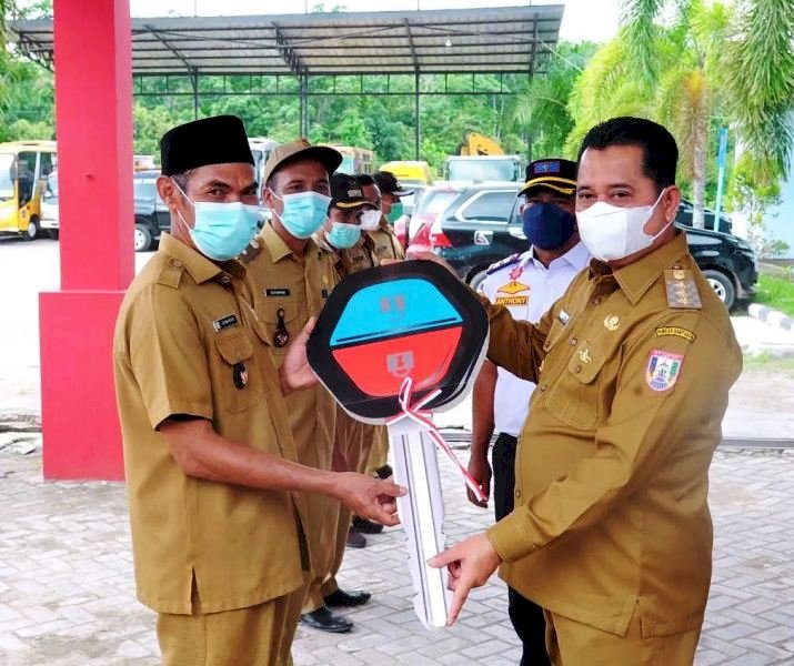 Bupati Banyuasin Askolani menyerahkan kunci mobil secara simbolis ke kepala desa, Senin (4/10). (Dinas Kominfo Banyuasin/rmolsumsel.id)