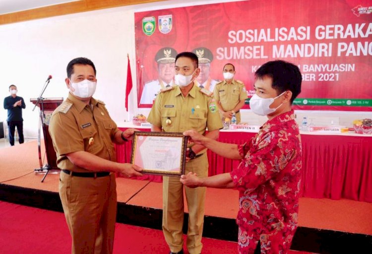 Bupati Banyuasin Askolani menyerahkan piagam penghargaan Mulyono yang merupakan pegiat program petani bangkit dan kemandirian pangan, Selasa (5/10). (Dinas Kominfo Banyuasin/rmolsumsel.id)