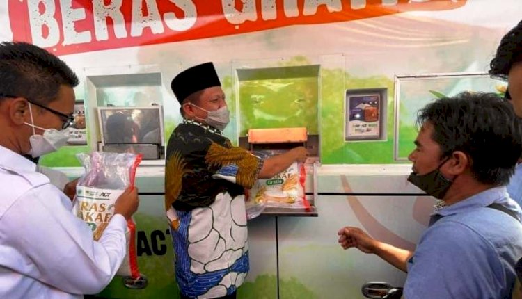 Bupati OKU Timur Lanosin Hamzah mengisi kantung beras dari ATM beras program dari ACT Sumatera Selatan, Rabu (6/10). (Dinas Kominfo OKU Timur/rmolsumsel.id) 