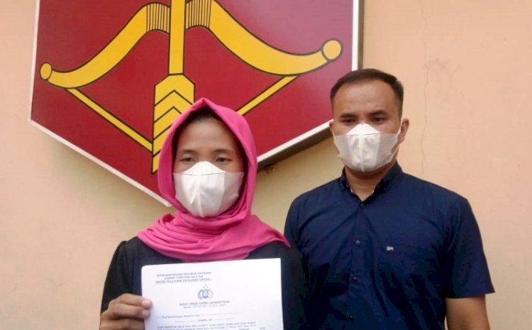 Dn ibu korban rudapaksa menunjukkan surat Laporan Polisi mengenai kasus rudapaksa anaknya yang dilakukan sang paman, Selasa (12/10). (Ist/rmolsumsel.id)