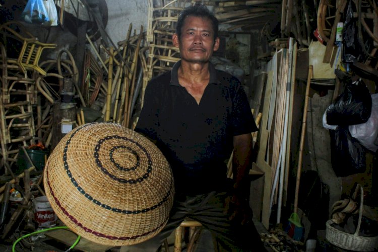 Pemilik Toko Era Jaya, Ikhsan Abdul Gani saat menunjukkan tudung saji yang dibuatnya. (Yuni Rahmawati/rmolsumsel.id)