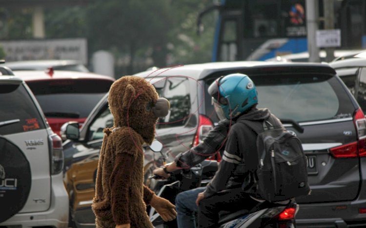 Badut karakter di salah satu persimpangan traffic light di kota Palembang. (humaidy/rmolsumsel)