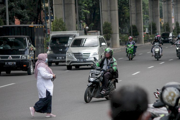 Seorang warga yang terlihat menyebrang tanpa melalui JPO akibat minimnya JPO. (Humaidy Kennedy/rmolsumsel.id)