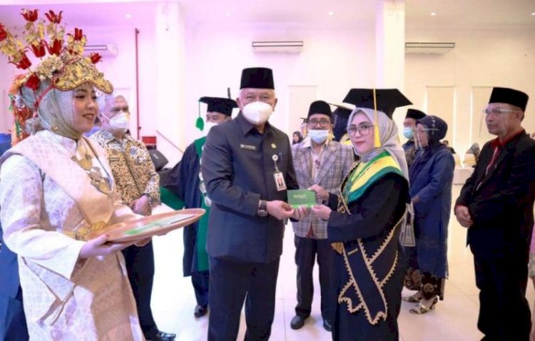 Sekda Kota Lubuklinggau A Rahman Sani menyerahkan penghargaan kepada seorang wisudawati STAI Bumi Silampari. (Dinas Kominfo Lubuklinggau/rmolsumsel.id) 