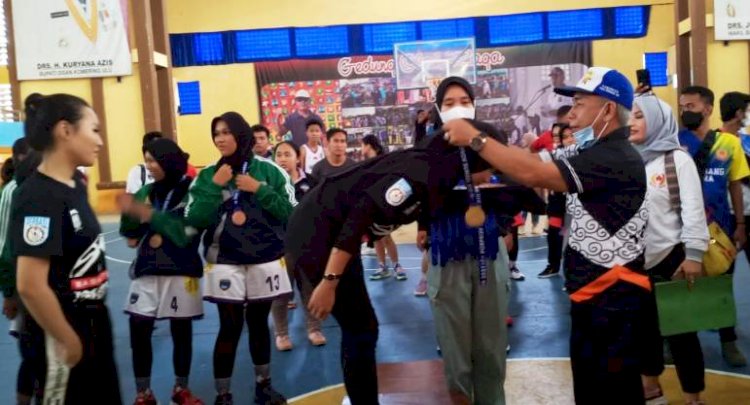 Koordinator atlet OKU Zayadi Achmad mengalungkan medali emas Porprov Sumsel XIII kepada tim basket putri Palembang, Minggu (21/11). (Ist/rmolsumsel.id)