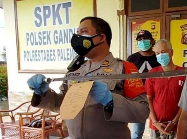 Kapolsek Gandus AKP Kusyanto menunjukkan parang panjang yang digunakan bapak anak pelaku penganiayaan kepada seorang pedagang di Gandus. (Ist/rmolsumsel.id)