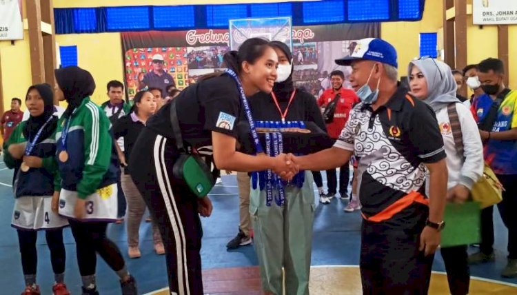 Koordinator Atlet OKU Zayadi Achmad saat mengalungkan medali emas untuk tim basket putri Palembang, Minggu (21/11). (Ist/rmolsumsel.id)