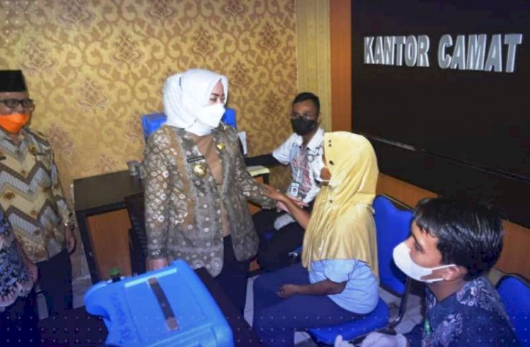 Bupati Musi Rawas Ratna Machmud berbincang dengan seorang warga yang mengikuti vaksinasi di kantor Camat Tugumulyo, Kamis (2/12). (Dinas Kominfo Musi Rawas/rmolsumsel.id)