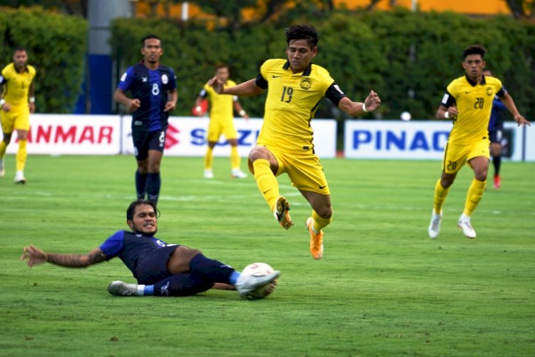 Penyerang Malaysia Akhyar Rashid menghindari tekel dari bek Kamboja Sambath Tes pada pertandingan pertama Grup B, Senin (6/12). (AFF Suzuki Cup 2020/rmolsumsel.id)