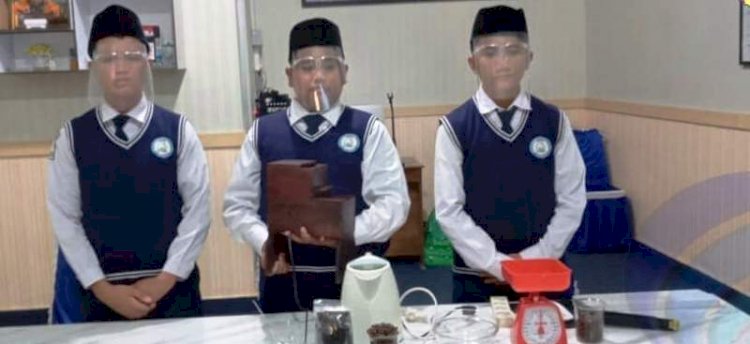Tiga siswa SMP IT Al-Kahfi Muaradua saat mempresentasikan mesin giling kopi dari limbah mebel, Rabu (8/12). (Dinas Kominfo OKUS/rmolsumsel.id)