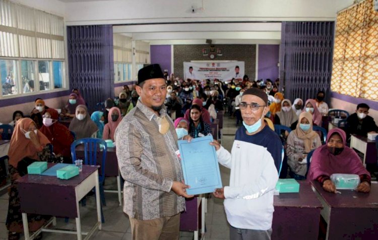 Anggota DPRD Kota Palembang Ridwan Saiman menyerahkan SK Mendikbud Ristek tentang penerima dana PIP kepada perwakilan orang tua siswa Yayasan Nurul Iman, Jumat (10/12). (Ist/rmolsumsel.id)
