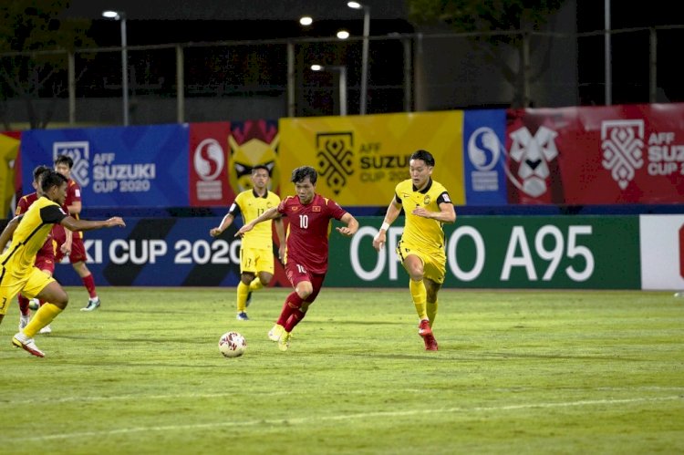 Penyerang Vietnam Nguyen Cong Phuong menggiring bola dibayangi pemain Malaysia pada laga Minggu malam (12/12). (AFF Suzuki Cup 2020/rmolsumsel.id)
