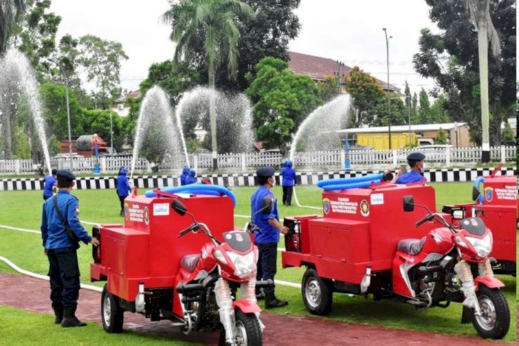 Petugas Satpol PP dan Damkar Kabupaten OKI memperagakan cara kerja Damkar mini di halaman Kantor Bupati OKI, Selasa (21/12). (Dinas Kominfo OKI/rmolsumsel.id)