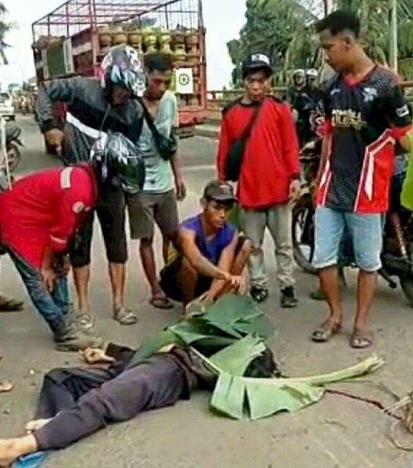 Warga di sekitar Jembatan Nilakandi melihat kondisi Mr X yang tewas terlindas truk, Kamis sore (23/12). (Ist/rmolsumsel.id)