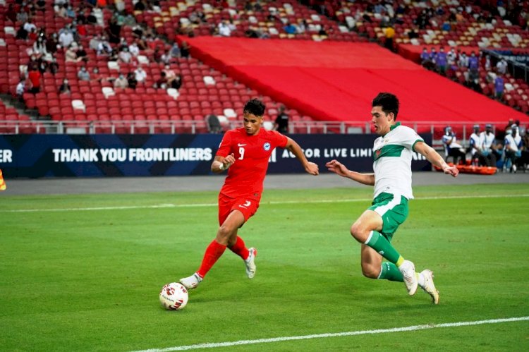 Bek Indonesia Elkan Baggott berupaya menghentikan pergerakan striker Singapura Ikhsan Fandi di leg 1 semifinal Piala AFF Suzuki 2020 di National Stadium, Rabu malam (22/12). (AFF Suzuki Cup 2020/rmolsumsel.id)