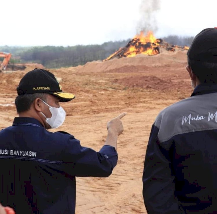 Kondisi sumur minyak ilegal yang masih terbakar selama dua bulan terakhir ditinjau Sekda Muba, Apriyadi (kiri). (ist/rmolsumsel.id)