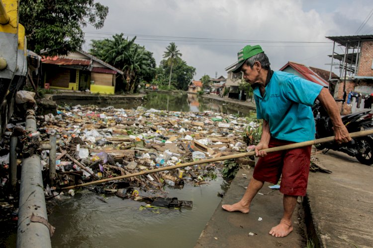 Warga Jalan Lebak Mulyo membersihkan sampah yang berada di sungai. (Humaidy Kenedy/Rmolsumsel.id). 