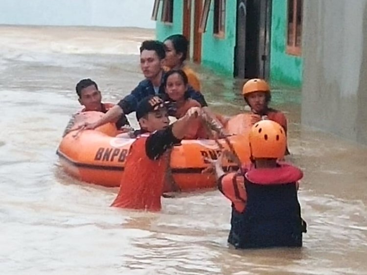 Petugas dari BPBD mengevakuasi warga Muara Enim yang rumahnya terendam banjir, Senin (27/12). (Ist/rmolsumsel.id) 