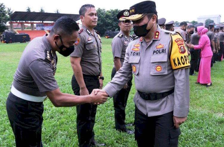 Kapolda Sumsel Irjen Toni Harmanto memberi selamat kepada salah satu perwira yang mendapat kenaikan pangkat pada upacara di lapangan sepak bola Athira Wirabakti Pakri, Palembang, Jumat (31/12). (Ist/rmolsumsel.id)