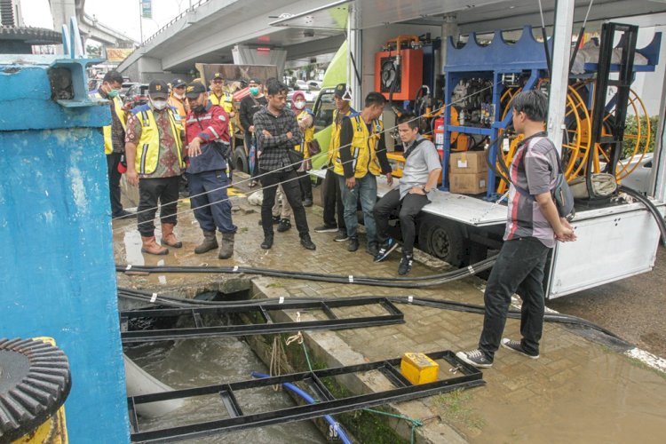 Petugas BBWS Sumatera VIII menyedot genangan air yang terjadi di Simpang Polda Sumsel menggunakan mobil pompa, Jumat pagi (7/1). (Humaidy Kenedy/rmolsumsel.id) 