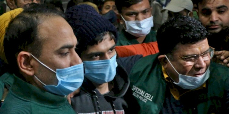Petugas polisi mengawal Niraj Bishnoi (tengah) melalui bandara New Delhi setelah dia ditangkap karena diduga membuat aplikasi online yang membagikan foto-foto wanita Muslim untuk 'lelang' virtual/Reuters