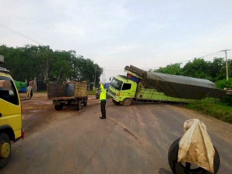 Personel Pataka Satlantas Polres Banyuasin mengatur arus lalu lintas yang terhalang fuso yang terperosok ke sisi jalan di KM 58 Palembang - Betung, Rabu pagi (12/1). (Instagram/rtmc_ditlantaspoldasumsel/rmolsumsel.id)