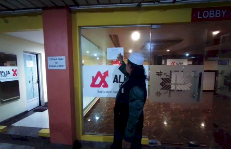 Kuasa hukum Januarizkhan, Jhon Fredi Joniansa dan partners saat menempel tulisan milik kliennya, Sabtu (22/1). Sebelumnya, kosan ini bernama JkKostel dan dilelang sepihak oleh bank sehingga berganti nama. (Dudy Oskandar/rmolsumsel.id)