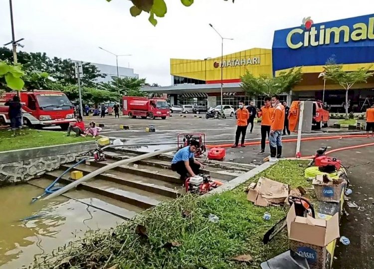 Petugas gabungan dan karyawan Citimall Baturaja bersama-sama mengatasi banjir yang merendam Jalan A Yani Baturaja, Rabu (2/2). (Diskominfo OKU/rmolsumsel.id)