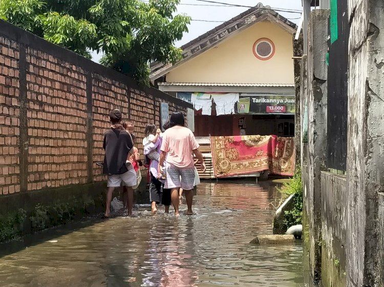 Warga RT 34 Jalan Sungai Item saat melintasi genangan banjir. (Humaidy Kennedy/rmolsumsel.id)