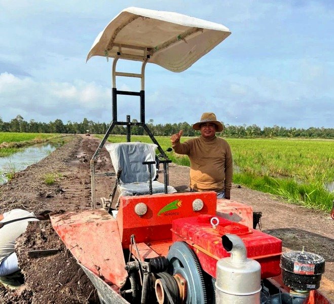 Bupati Banyuasin Askolani usai menjajal Tractor Boat untuk membajak sawah yang terendam air. (Diskominfo Banyuasin/rmolsumsel.id)