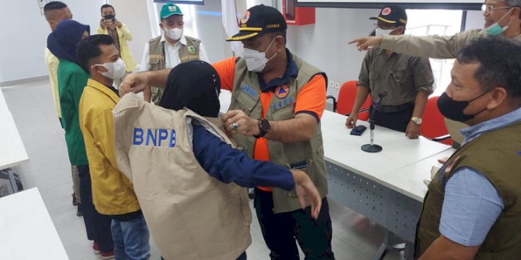 Deputi Bidang Rehabilitasi dan Rekonstruksi BNPB Jarwansah memakaikan rompi BNPB kepada perwakilan mahasiswa yang menjadi relawan pendataan kerusakan bangunan akibat gempa Sumbar. (BNPB/rmolsumsel.id)