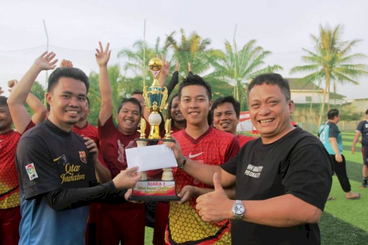 Aspidum Kejati Sumsel Sutikno (kanan) menyerahkan trofi dan hadiah kepada tim Ekbis yang menjadi juara di RMOL Sumsel Mini Soccer Challenge, Sabtu (5/3). (Humaidy Kenedy/rmolsumsel.id)