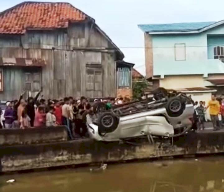 Detik-detik mobil yang dirusak warga diceburkan ke anak Sungai Musi, Minggu (13/3). (Ist/rmolsumsel.id)